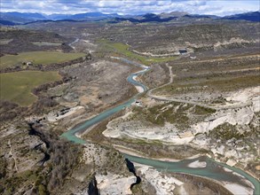 Aerial view of a picturesque landscape with a river meandering through a valley, surrounded by