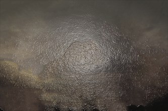 Abstract artwork with a dark and moody atmosphere, featuring a textured surface with a metallic