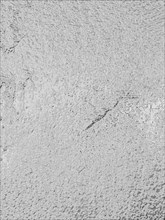 An abstract grey textured surface resembling small pebbles or rough concrete