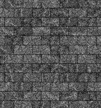 Grey textured roof shingles arranged in a repetitive pattern