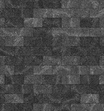 A close-up of textured grey roof shingles forming a rough, patterned surface