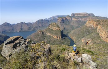 Young man standing on a rock in canyon landscape, river bend at Blyde River Canyon with Three