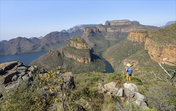 Young man standing on a rock in canyon landscape, river bend at Blyde River Canyon with Three