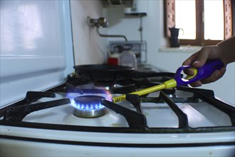 Person lighting a fire on a butane stove