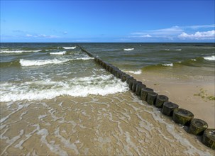 Sandy beach beach with wooden groyne in the Baltic Sea on the island of Usedom, clouds in the blue