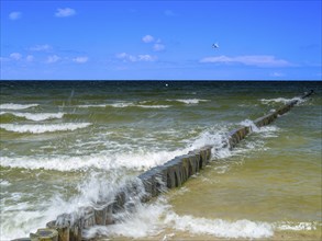 Spray splashes on a wooden groyne on a sandy beach on the Baltic Sea on the island of Usedom,