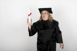 Recent graduate woman, dressed in cap and gown, showing off his degree