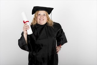 Recent graduate woman, dressed in cap and gown, showing off his degree