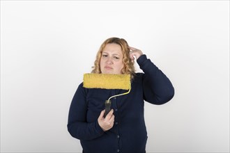 Woman looking confused at a paint roller