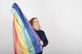 Studio shot of woman holding LGBT rainbow flag