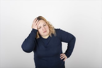 Stressed and tired woman touches her head because of a headache