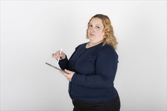 Woman using tablet and digital pen looking seriously at camera