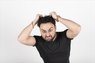 Latin young man very angry. White background