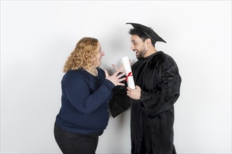 Recent graduate man, dressed in cap and gown, showing off his degree celebrating with his family