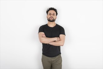 Portrait of young man with arms crossed looking at camera