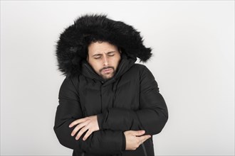 Man wearing black coat with very cold expression