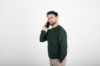 Portrait of a latin man talking on the phone. White background