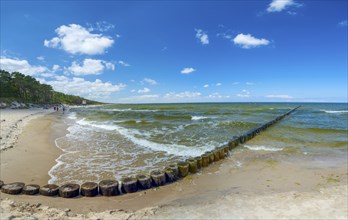 Sandy beach beach with wooden groyne in the Baltic Sea on the island of Usedom, clouds in the blue