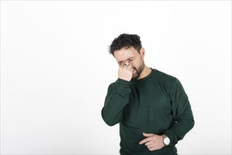 Stressed and tired man touches his head because of a headache