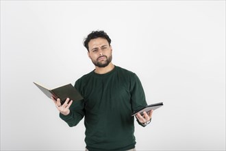 Thoughtful man holding a book in one hand and an e-reader in the other