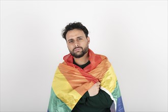 Studio shot of man holding LGBT rainbow flag