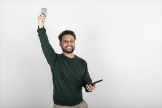 Happy man celebrating an online purchase with his credit card