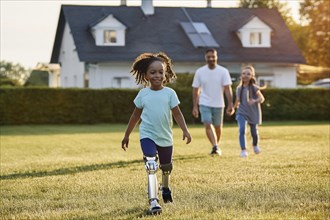 Joyful girl with prosthetic leg runs in the garden, followed by her father and sister, ai