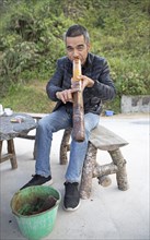 Vietnamese man smoking a thick bamboo pipe, Ha Giang province, Vietnam, Asia