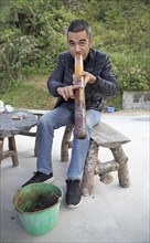 Vietnamese man smoking a thick bamboo pipe, Ha Giang province, Vietnam, Asia