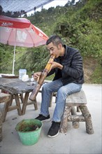 Vietnamese man smoking a thick bamboo pipe, Ha Giang province, Vietnam, Asia