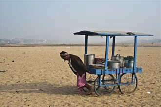 A street vendor is pulling his cart in the sand of the dry riverbed of the Phalgu river (Gaya,