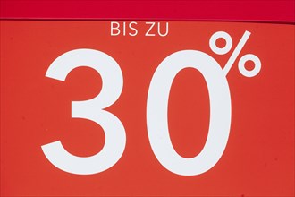 Red sign 30% discount on a shop window, Germany, Europe