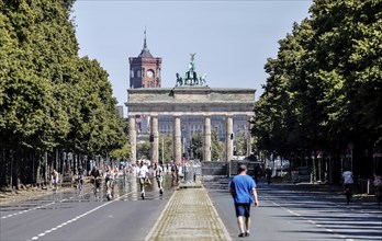 Pedestrians, cyclists and e-scooters on the road on the Strasse des 17 Juni at the Brandenburg Tor,