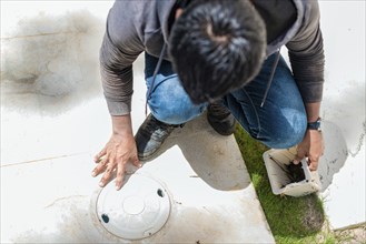 Worker changing swimming pool skimmer basket. Cleaning and maintenance of the swimming pool skimmer