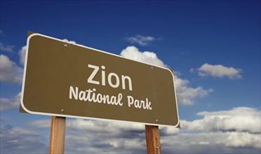 Zion national park (utah) road sign against blue sky and clouds