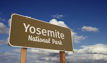 Yosemite national park (california) road sign against blue sky and clouds