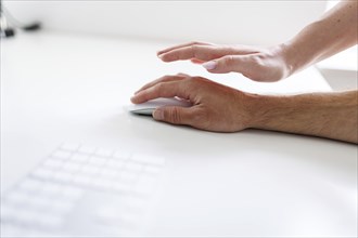 Topic: Sexual violence in the workplace. A woman's hand reaches for a man's hand at a desk in