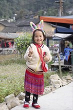 Vietnamese girl with rabbit ears and flowers on her back, Lungcam Cultural Tourist Village, Ha