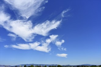 Cirrus or cirrus clouds in the blue sky over the mountains of the Bavarian Forest, Plattling, Lower