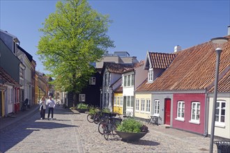 Picturesque old town street with colourful houses and bicycles under a blue sky in spring, Odense,