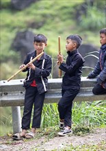 Vietnamese boys playing traditional flutes in the northern mountains, Ha Giang province, Vietnam,