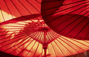 Red parasol seen from below against the sun, Bangkok, Thailand, Asia