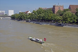 A traditional boat with a red sail on a river in an urban environment, Rhine, Basel, Switzerland,