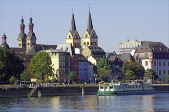 A picturesque town view with churches, houses and a river cruise ship on the river, Moselle,