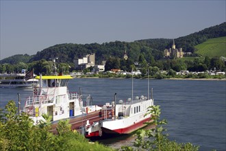 A ferry on the riverbank with a town and wooded hills in the background, Rhine, Andernach,