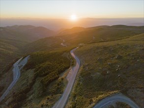 Aerial view of a winding road through hilly mountains at sunset, aerial view, Sierra Nevada,