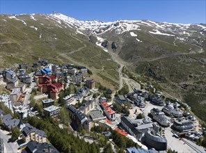 Aerial view of a mountain village with modern buildings in a snow-covered alpine environment,