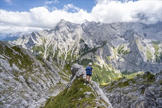 Mountaineer climbing Waxenstein, Alpspitze Wetterstein range in the background,