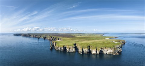 Aerial panorama of the rugged coastal landscape at Duncansby Head with the lighthouse on the right,