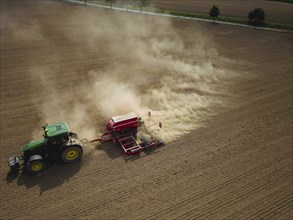 A tractor with a Horsch PRONTO DC 6 seed drill sowing in a dry field in late summer., Doma, Saxony,